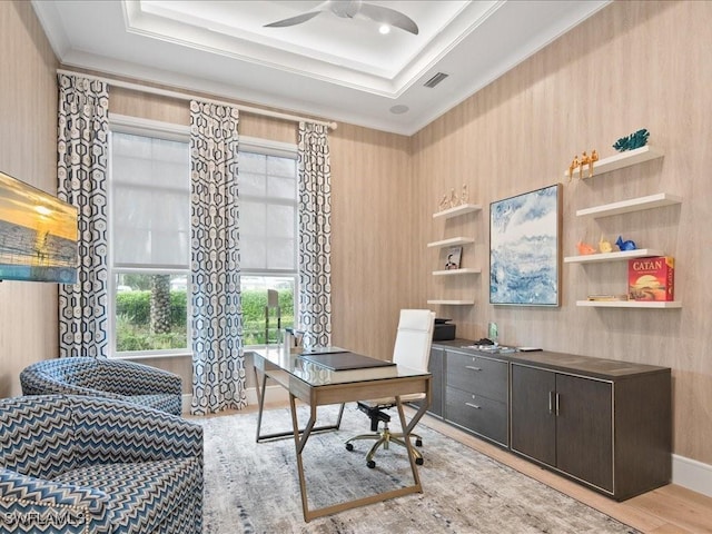 home office with a ceiling fan, a tray ceiling, visible vents, and crown molding