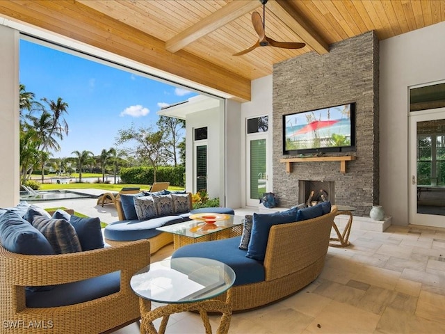 view of patio / terrace featuring an outdoor living space with a fireplace and a ceiling fan