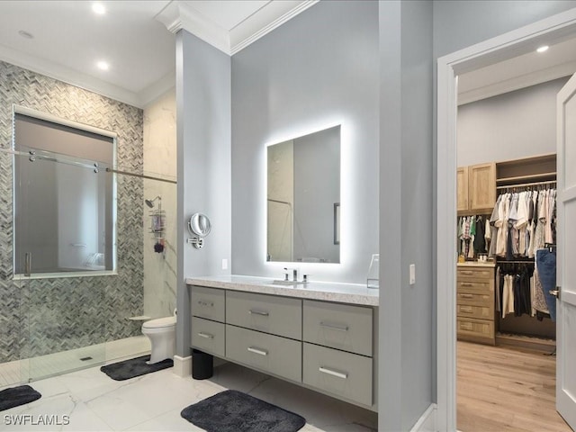 full bath featuring a walk in closet, toilet, ornamental molding, vanity, and a walk in shower