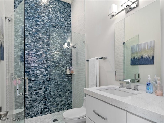 bathroom featuring toilet, a stall shower, and vanity