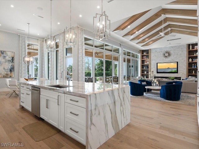 kitchen with a large island, open floor plan, decorative light fixtures, white cabinetry, and a notable chandelier