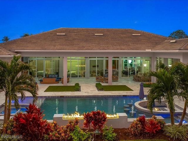 back of property featuring an outdoor pool, a patio area, outdoor lounge area, and stucco siding