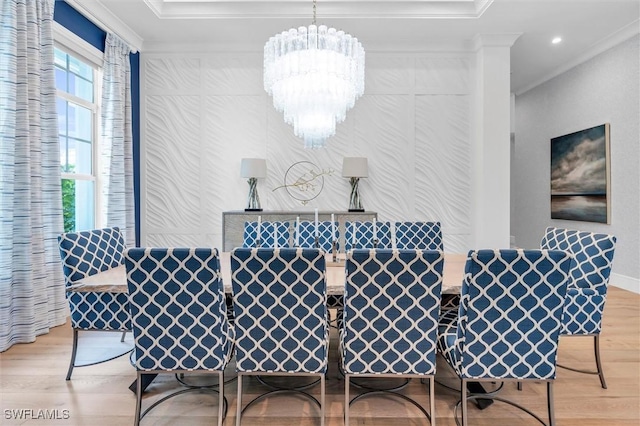 dining area with a chandelier, light wood-style floors, crown molding, and baseboards