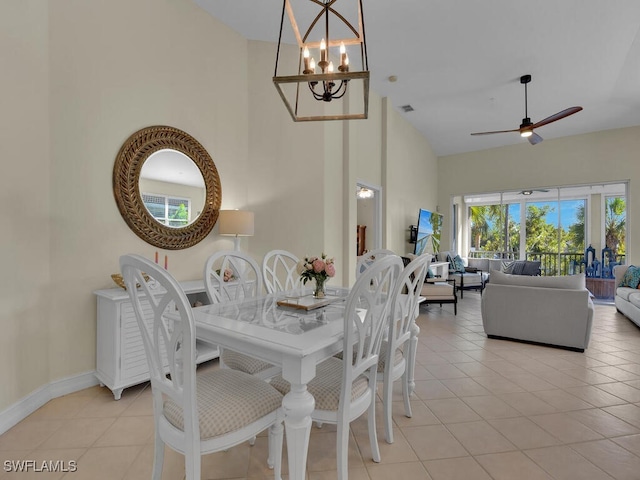 dining space featuring high vaulted ceiling, ceiling fan with notable chandelier, and light tile patterned floors