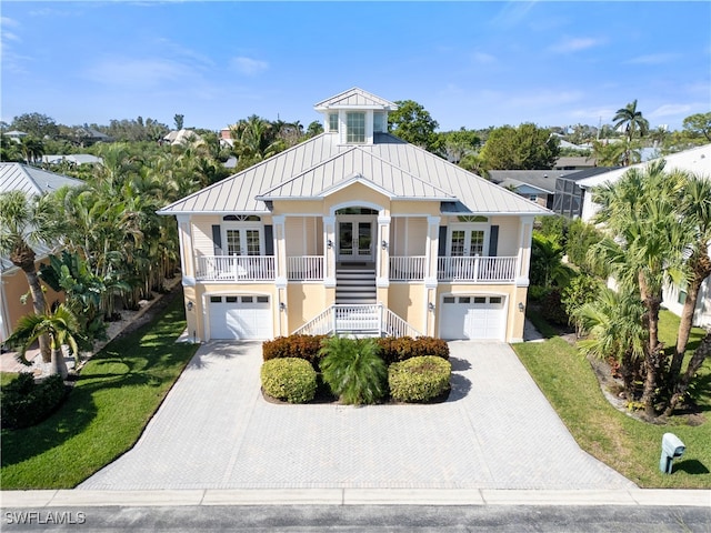 beach home with a front yard, french doors, a porch, and a garage