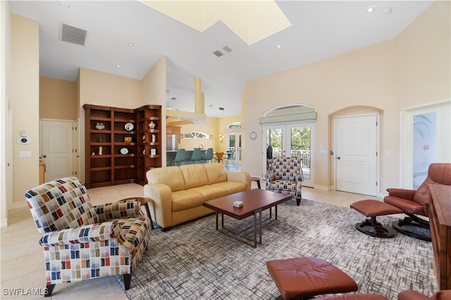 living room featuring french doors, light tile patterned floors, and a high ceiling