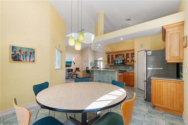 dining area featuring light tile patterned floors and a towering ceiling