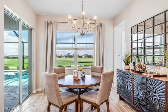 dining room with an inviting chandelier and light hardwood / wood-style flooring