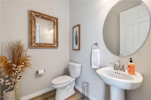 bathroom featuring hardwood / wood-style flooring and toilet