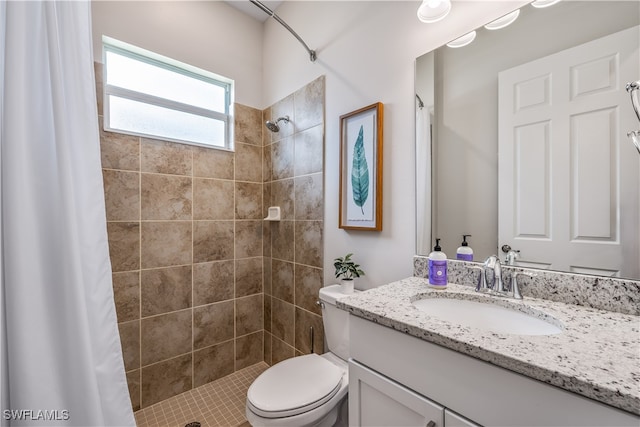 bathroom with walk in shower, vanity, and toilet