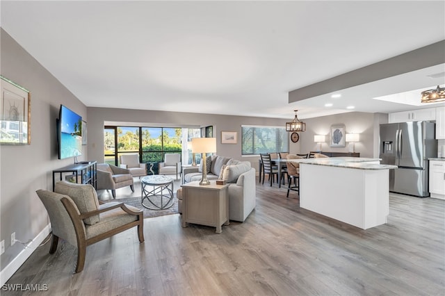 living room with a notable chandelier and light hardwood / wood-style flooring