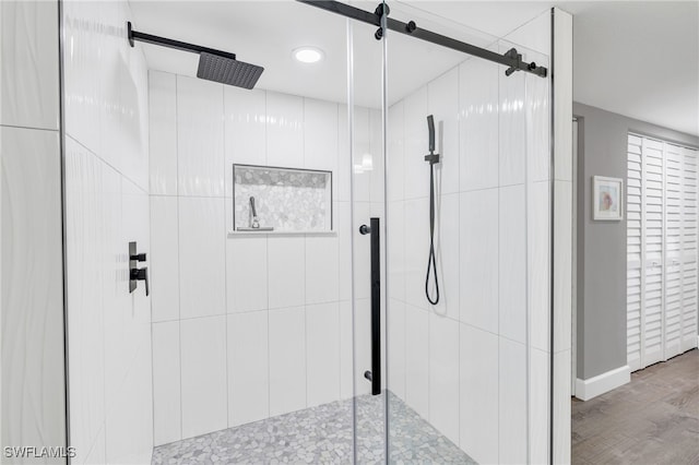 bathroom featuring hardwood / wood-style floors and a shower with shower door