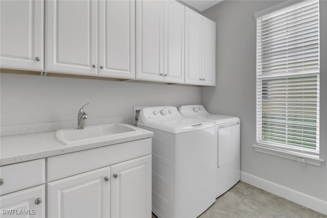 laundry room with washer and dryer, sink, and cabinets