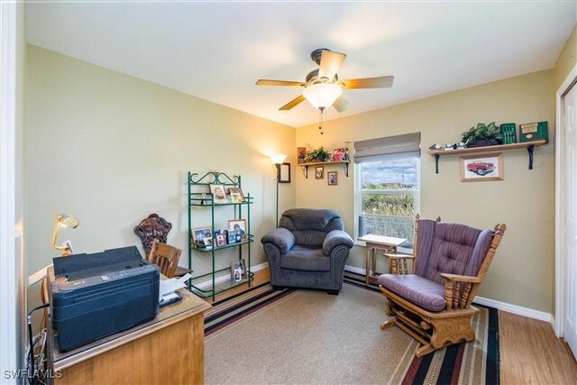 living area featuring wood-type flooring and ceiling fan