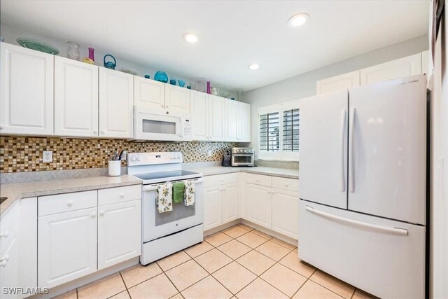 kitchen featuring backsplash, white cabinetry, light tile patterned flooring, and white appliances