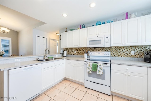 kitchen featuring backsplash, white cabinetry, sink, and white appliances