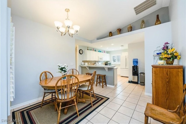 dining room featuring lofted ceiling, light tile patterned floors, and an inviting chandelier