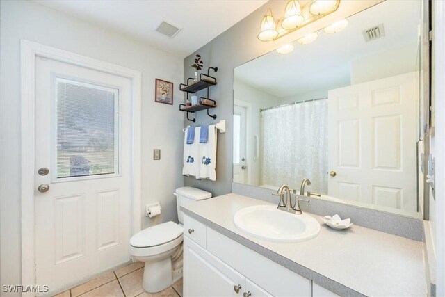 bathroom featuring toilet, vanity, and tile patterned floors