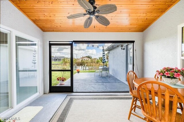 sunroom / solarium with ceiling fan, wooden ceiling, and lofted ceiling