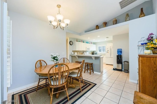 dining area with lofted ceiling, a chandelier, sink, and light tile patterned floors