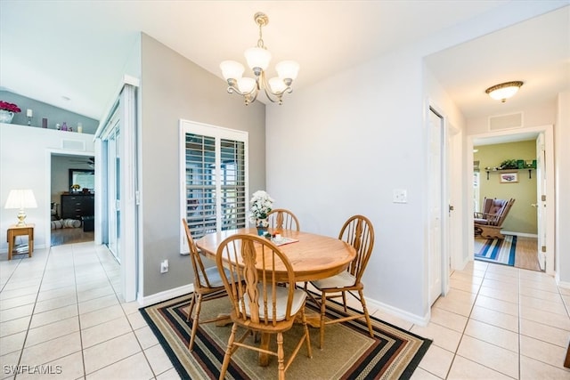 dining room featuring a notable chandelier, lofted ceiling, and light tile patterned flooring