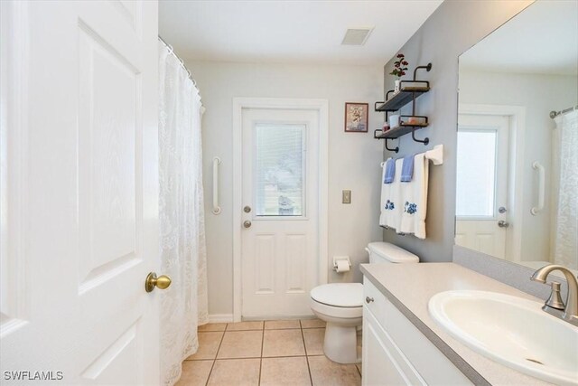 bathroom featuring vanity, toilet, tile patterned flooring, and plenty of natural light