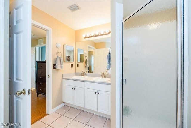 bathroom featuring tile patterned flooring, vanity, and walk in shower