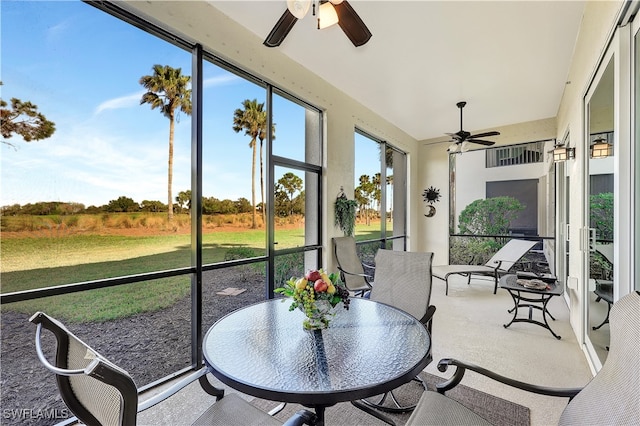 sunroom / solarium featuring a rural view and ceiling fan