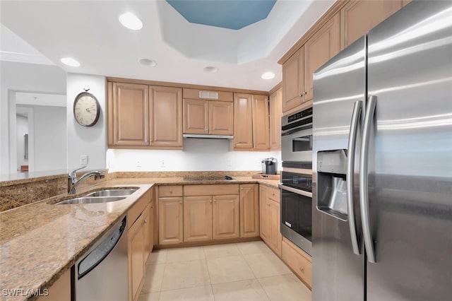 kitchen featuring appliances with stainless steel finishes, sink, light stone counters, and light tile patterned floors