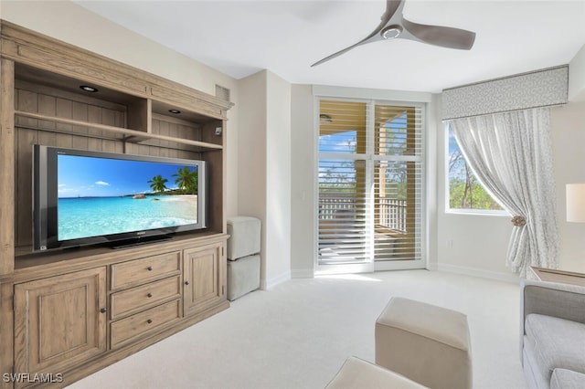 carpeted living room with ceiling fan