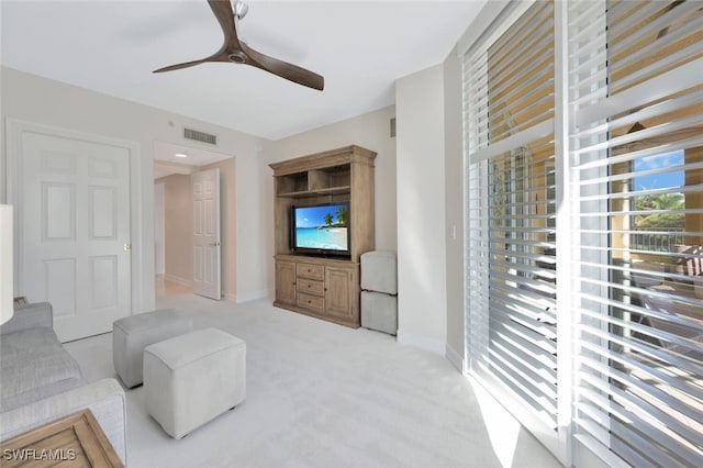 carpeted living room with ceiling fan