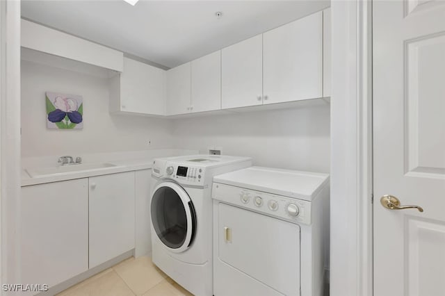 laundry room with light tile patterned floors, cabinets, sink, and washer and dryer