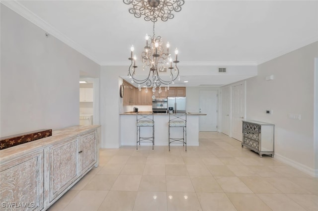 kitchen featuring a kitchen bar, an inviting chandelier, light tile patterned floors, crown molding, and appliances with stainless steel finishes