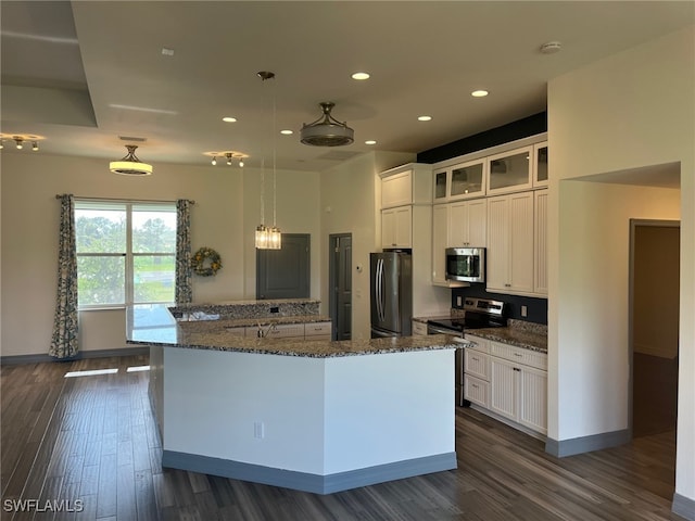 kitchen with dark hardwood / wood-style floors, white cabinetry, appliances with stainless steel finishes, and a center island