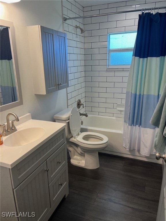 full bathroom with hardwood / wood-style floors, shower / bath combo with shower curtain, vanity, and toilet