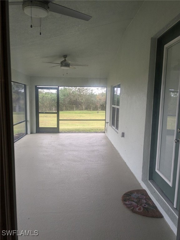 unfurnished sunroom featuring ceiling fan