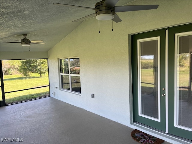 unfurnished sunroom with lofted ceiling and ceiling fan