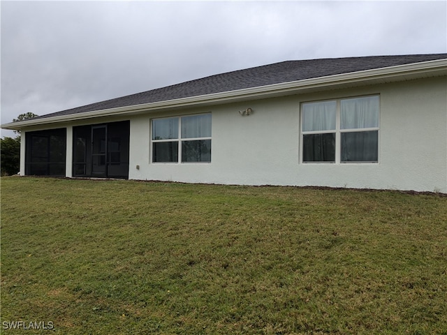 back of property with a sunroom and a yard