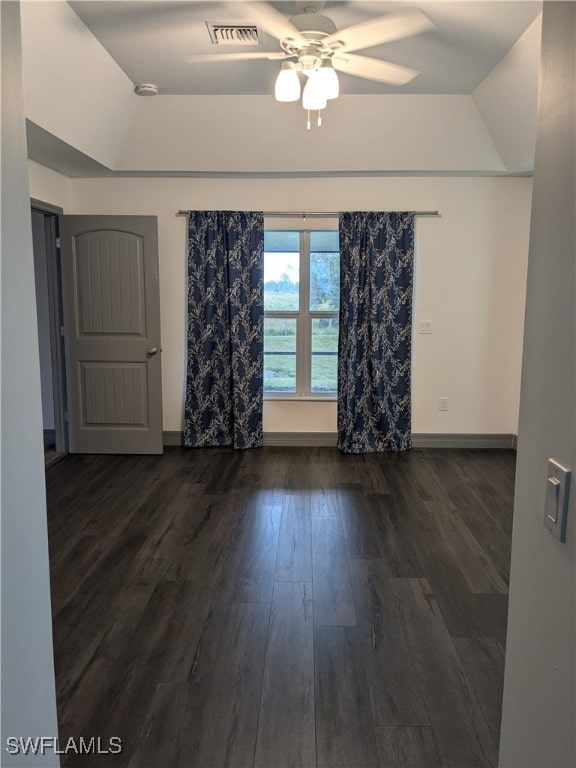 spare room featuring ceiling fan, dark hardwood / wood-style floors, and a tray ceiling