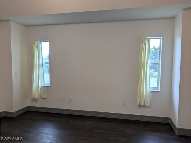 spare room with dark wood-type flooring