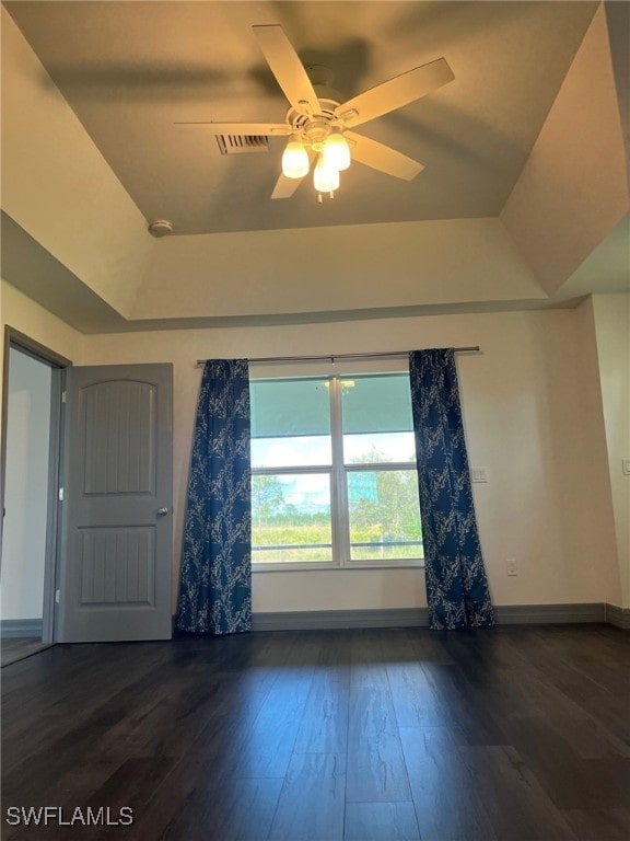 spare room with dark hardwood / wood-style flooring and ceiling fan