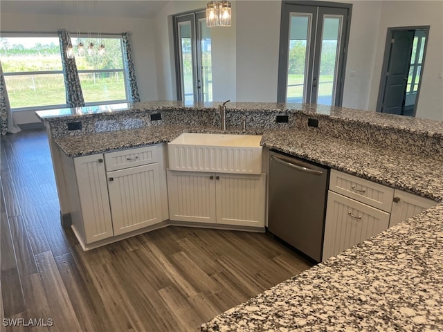 kitchen with light stone counters, dark hardwood / wood-style flooring, pendant lighting, sink, and dishwasher