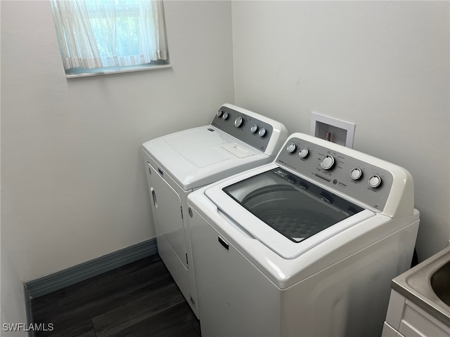 clothes washing area with dark wood-type flooring and washing machine and clothes dryer