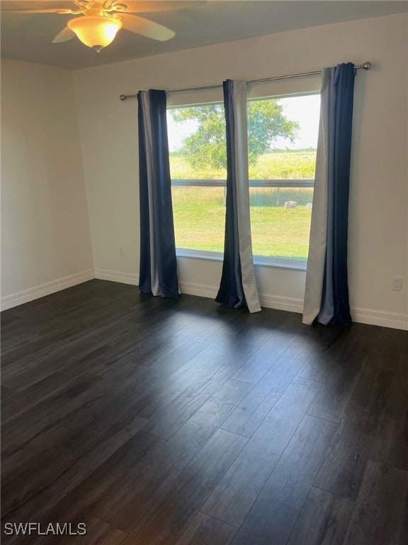 empty room featuring dark hardwood / wood-style flooring and ceiling fan