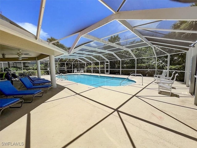 view of pool with a patio, glass enclosure, and ceiling fan