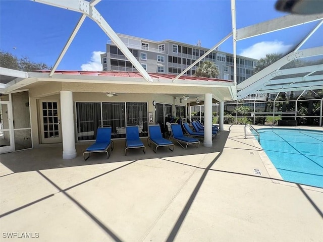 view of swimming pool with ceiling fan, a patio area, and a lanai