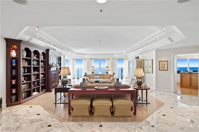 interior space featuring light hardwood / wood-style floors, a raised ceiling, and ornamental molding