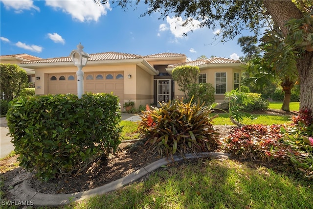 mediterranean / spanish-style home with a garage