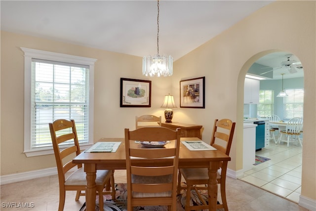 tiled dining room featuring vaulted ceiling and ceiling fan with notable chandelier