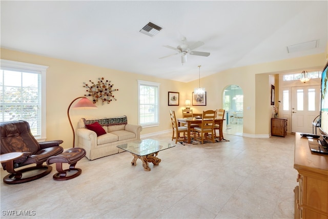 living room with ceiling fan with notable chandelier and vaulted ceiling